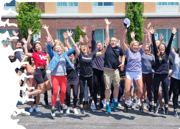 HealthSource team jumping in outdoor team photo