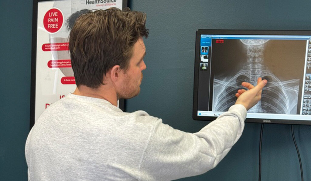 A chiropractor at HealthSource of Downtown Mokena reviewing patient X-rays.