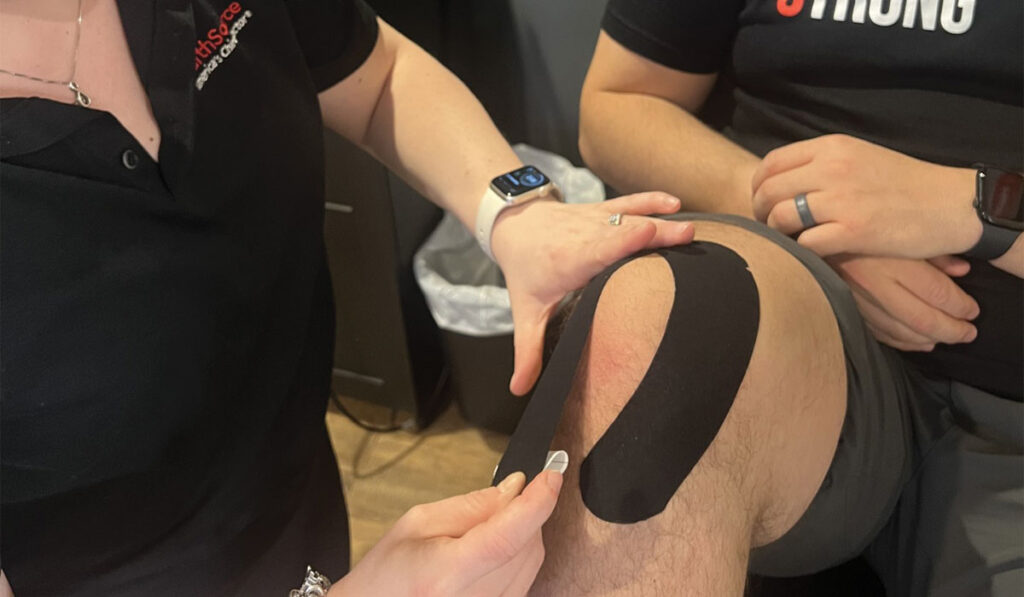 A patient at HealthSource of Troy receiving Kinesiology Taping treatment.