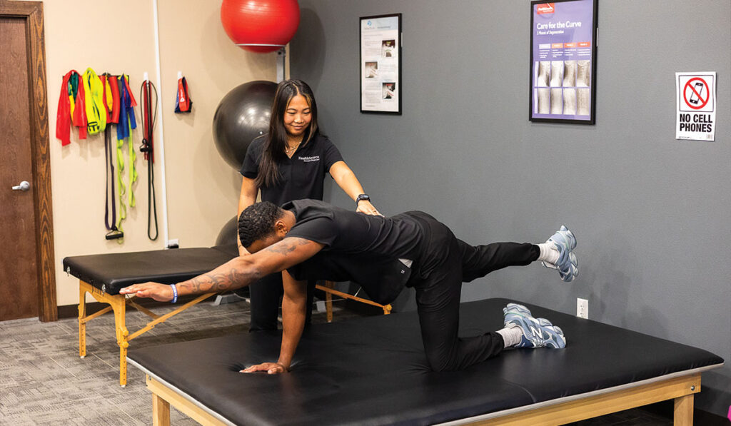 A patient stretching with a Rehabilitation Specialist at HealthSource of Pensacola.