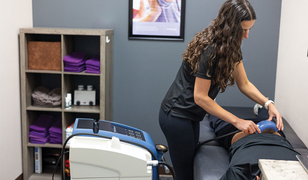 A patient laying face down preparing to receive Shockwave Therapy at HealthSource of Nine Mile.