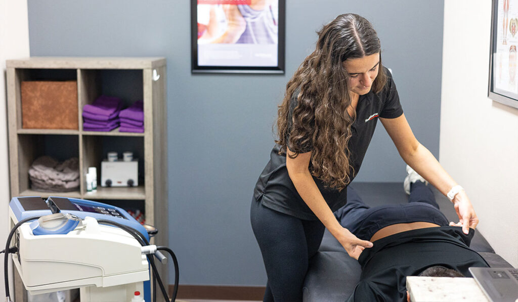 A patient laying face down preparing to receive Shockwave Therapy at HealthSource of Nine Mile.