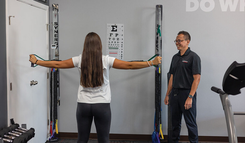 A patient doing stretches with a Rehabilitation Specialist at HealthSource of Nine Mile.