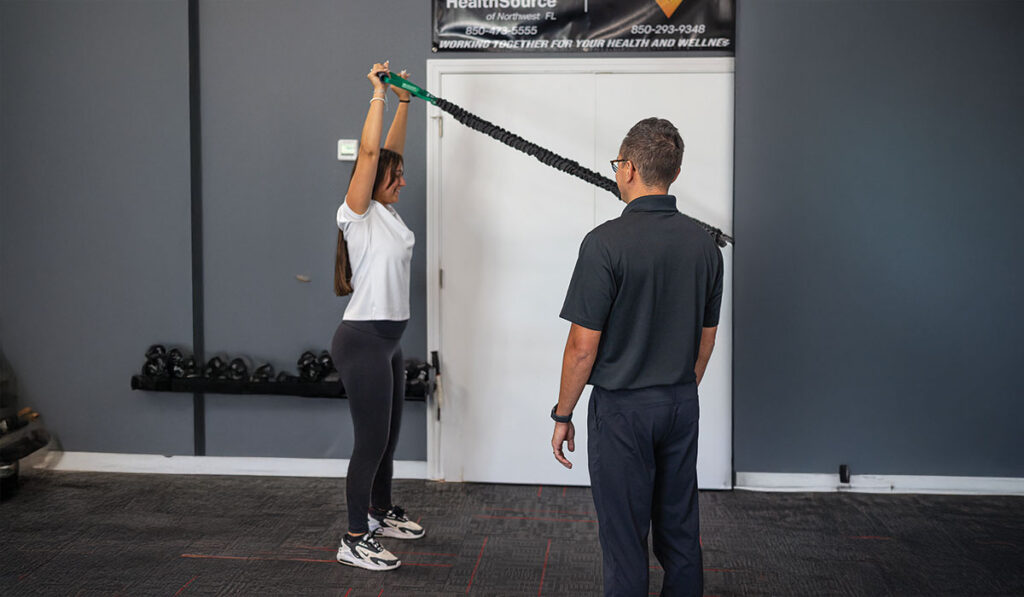 A patient doing stretches with a Rehabilitation Specialist at HealthSource of Nine Mile.