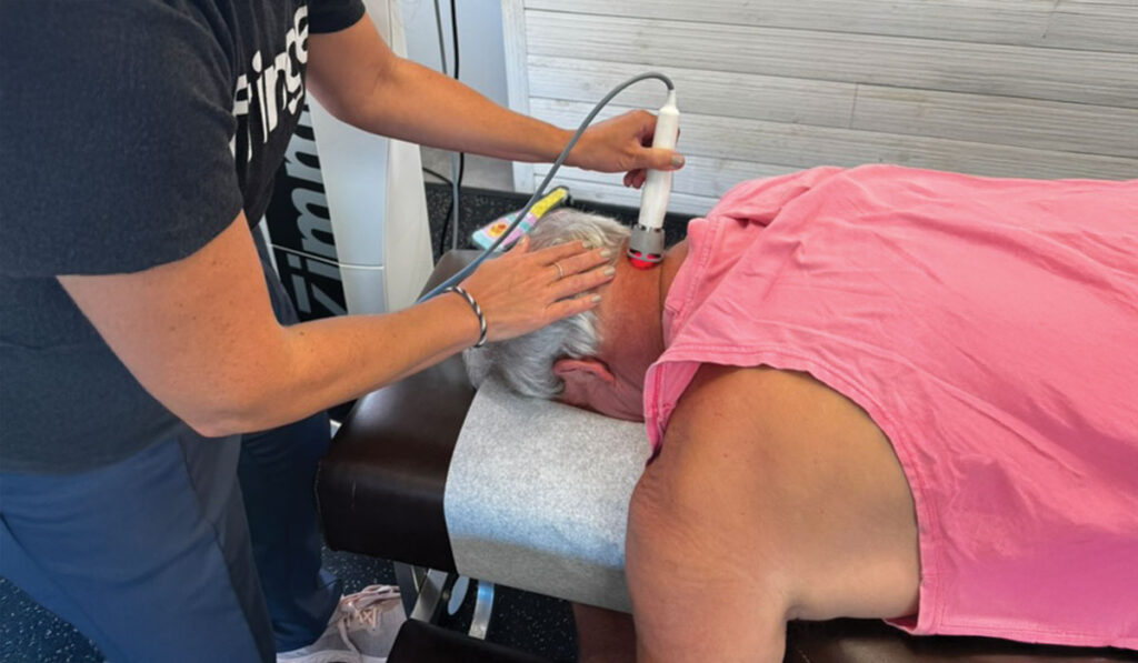 A patient at HealthSource of Downtown Mokena receiving Laser Therapy on the back of their neck.