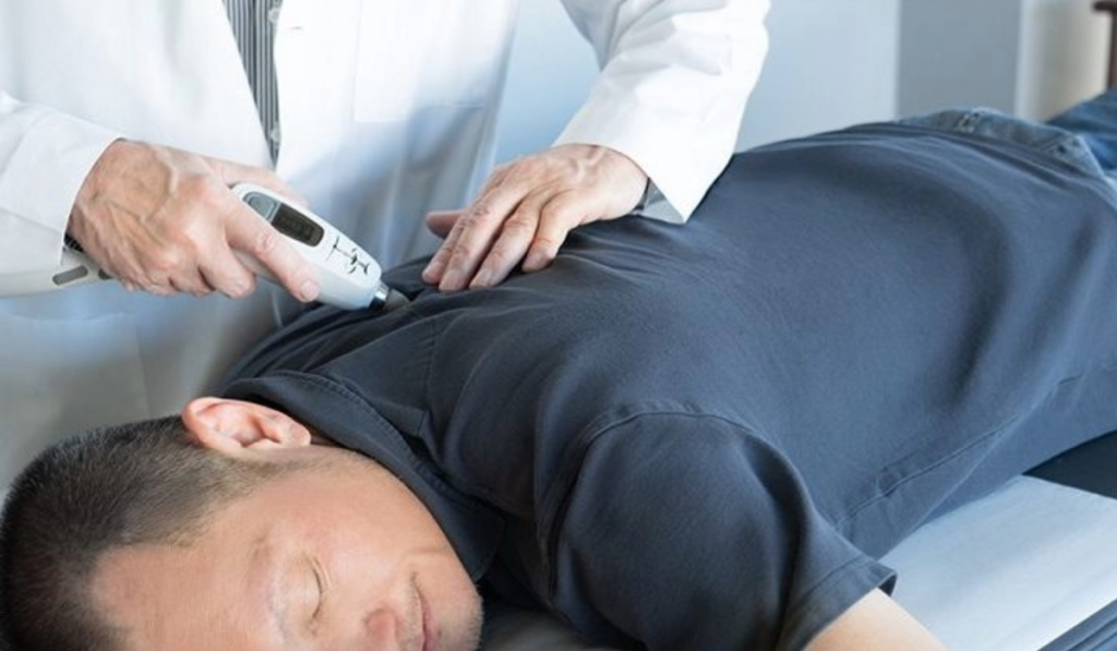 A chiropractic patient being treated using the Activator V.