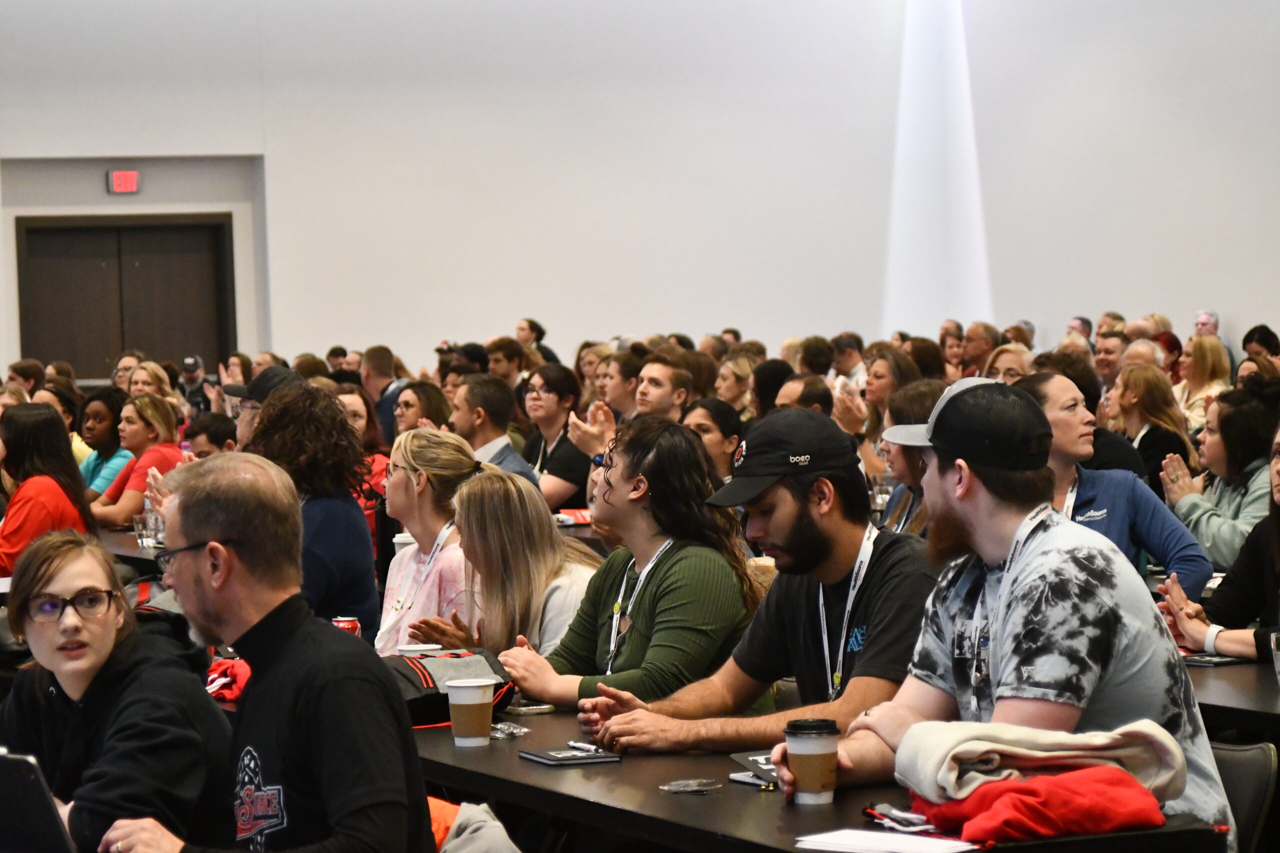 Supercamp conference tables full of team members listening attentively