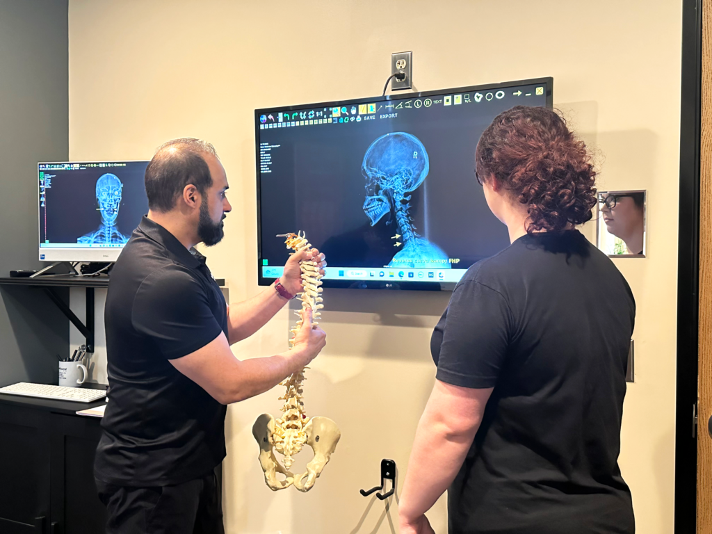 Team member learning with model spine and x-ray. 