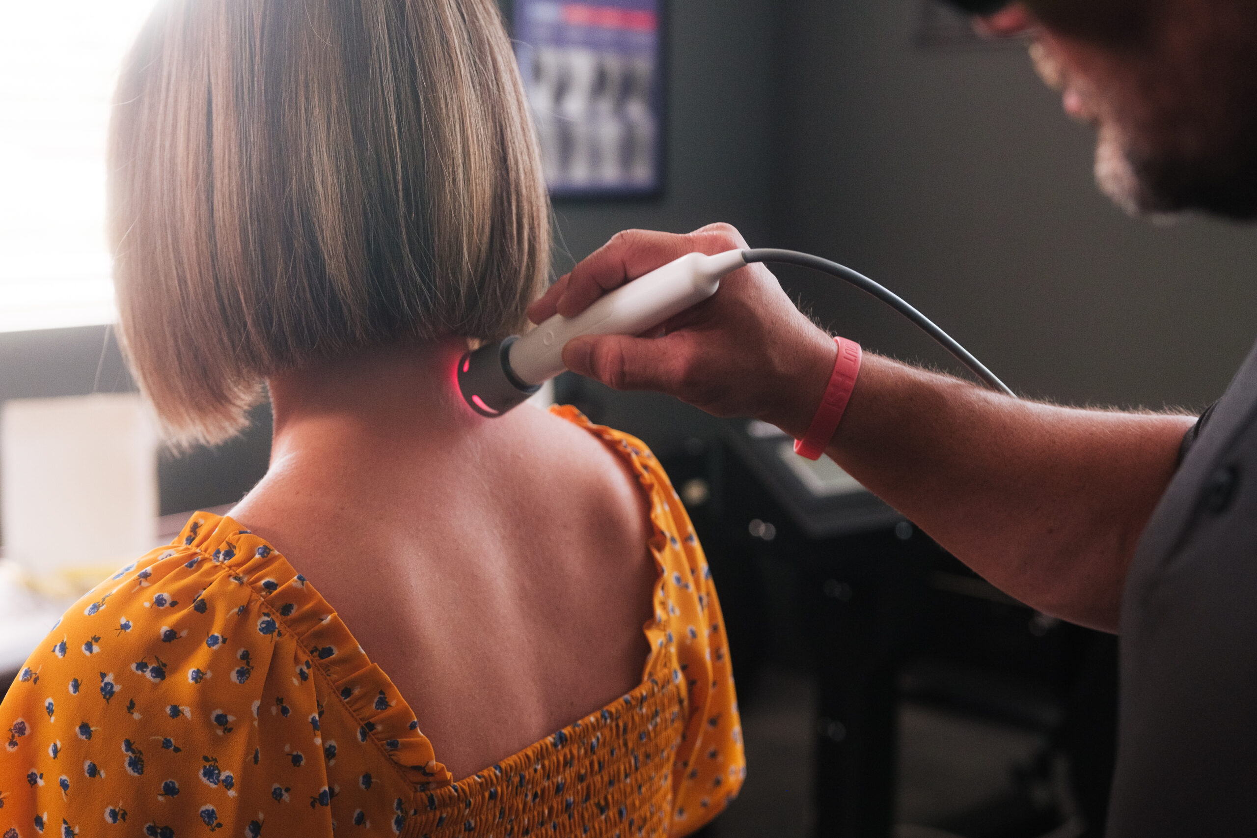 A HealthSource team member treats a patient's neck with laser therapy. 
