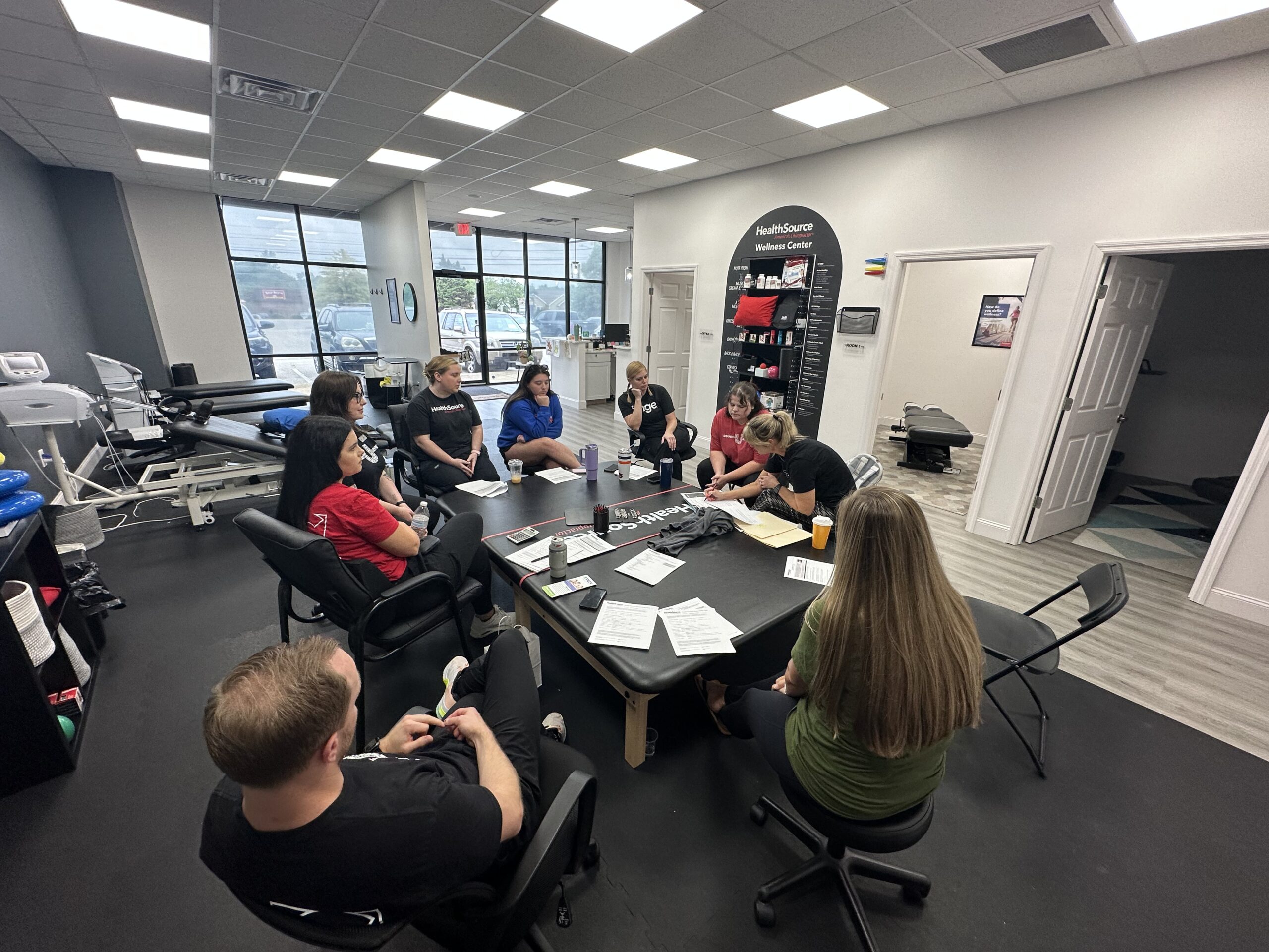 Team members sit around a table during a training meeting.