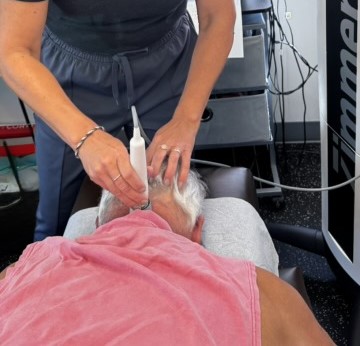 A patient receiving Laser Therapy treatment on their neck at HealthSource of Downtown Mokena.