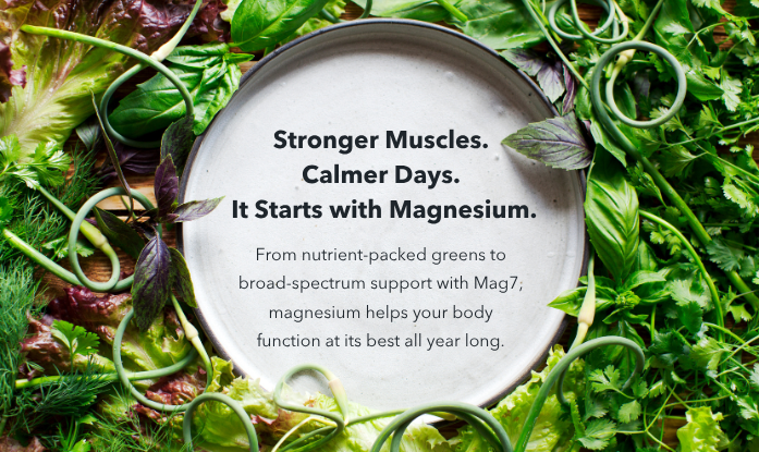 Flat lay of a white plate surrounded by fresh green herbs and vegetables with text that reads: ‘Stronger Muscles. Calmer Days. It Starts with Magnesium.’ promoting the benefits of Mag7 magnesium supplement.