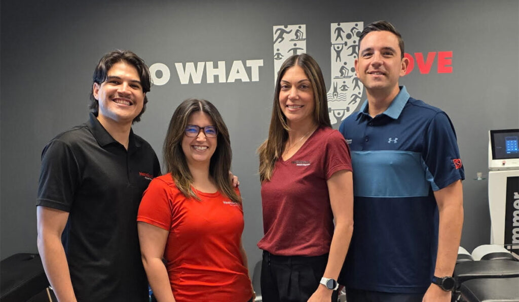 Dr. Bruno Contro, Denise Contro and the team at HealthSource of Doral posing together inside the clinic.