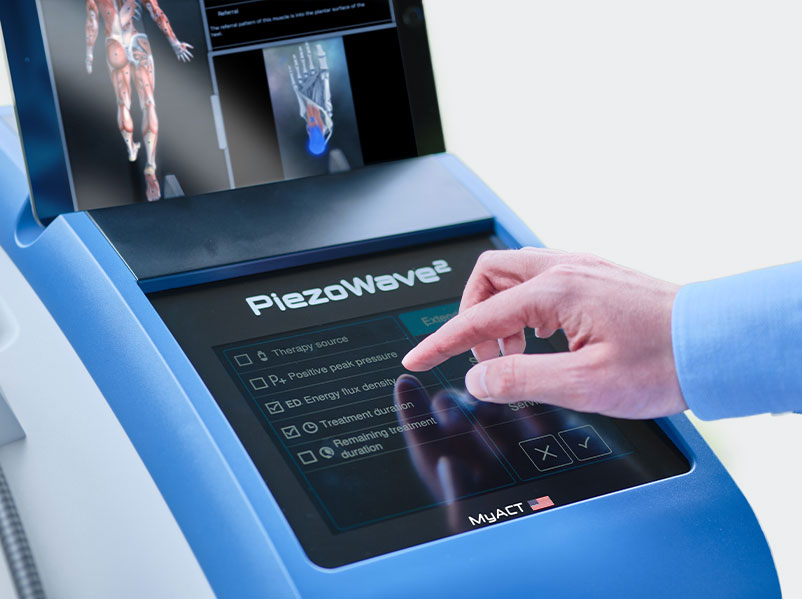 Close-up of PiezoWave2 shockwave therapy device screen with clinician selecting treatment settings
