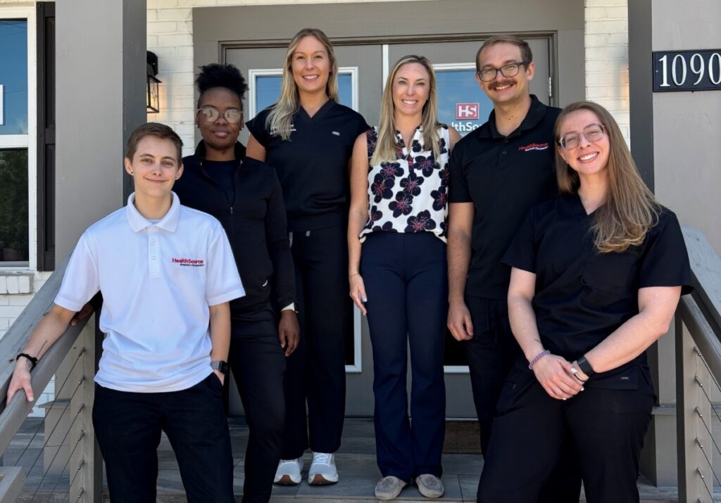 The team at HealthSource of Pensacola posing together in front of the clinic