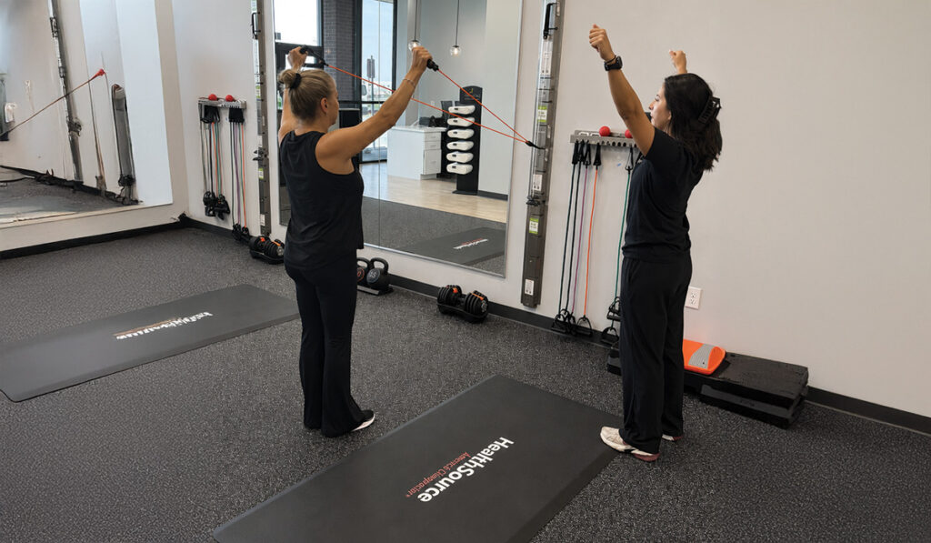 A patient practicing progressive rehabilitation and functional exercise movements in a HealthSource clinic.