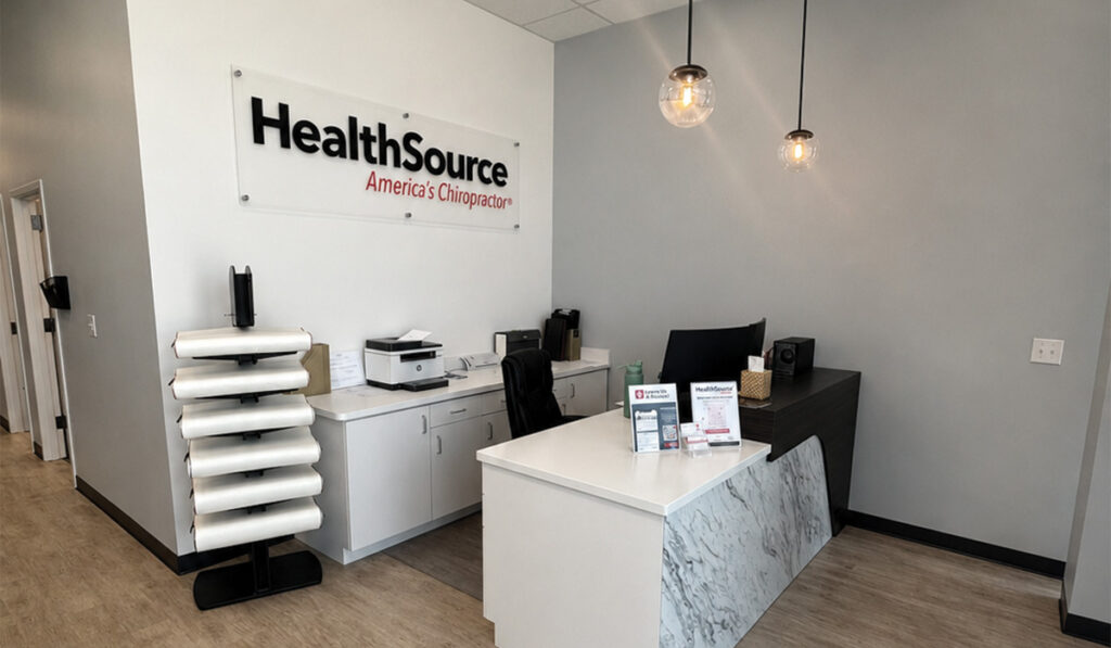 The front desk area and HealthSource branded sign in the front area of the HealthSource of Burleson clinic.